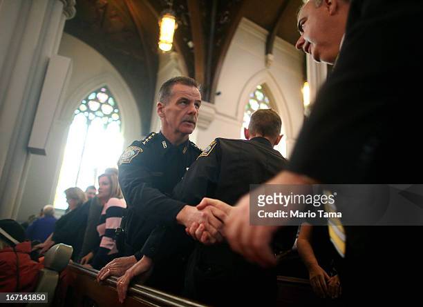 Boston Police Department Superintendent Kevin Buckley shakes hands with Boston Police Commissioner Edward Davis during Mass at the Cathedral of the...