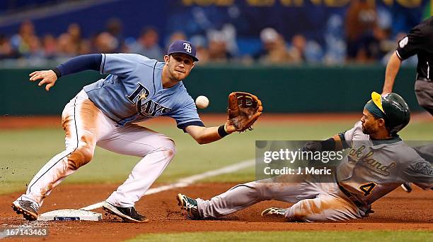 Infielder Evan Longoria of the Tampa Bay Rays takes the throw at third as designated hitter Coco Crisp of the Oakland Athletics steals third during...