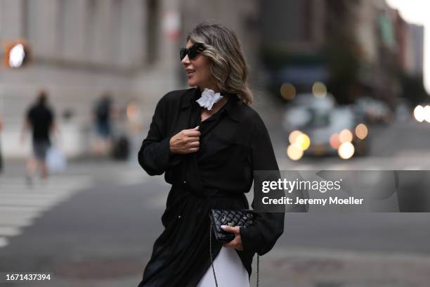 Olga Ferrara is seen wearing a complete outfit from JNBY official, consisting of black sunglasses in butterfly shape, a black choker with a big white...