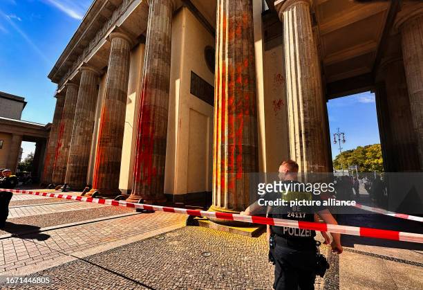 September 2023, Berln, Berlin: The pillars of the Brandenburg Gate, which members of the climate protection group Last Generation sprayed with orange...