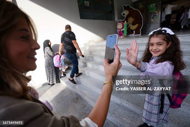 Parent snaps a picture of her child on the the first day of school, in Kuwait City on September 17, 2023.