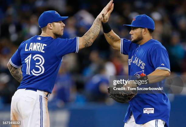 Melky Cabrera of the Toronto Blue Jays celebrates their victory with Brett Lawrie during MLB game action against the New York Yankees on April 21,...