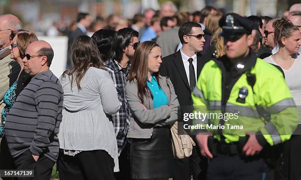 Police officer keeps watch as people wait on line to attend the wake for 29-year-old Krystle Campbell who was one of three people killed in the...