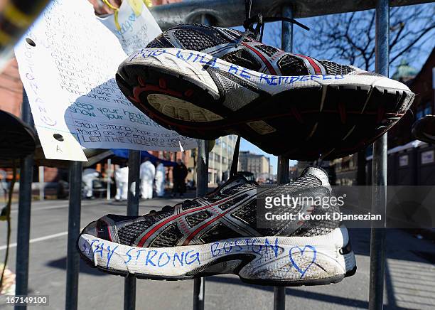 Running shoes are placed at a makeshift memorial for victims near the finish line of the Boston Marathon bombings at the intersection of Newbury...