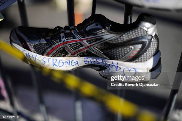 Running shoes are placed at a makeshift memorial for victims near the finish line of the Boston Marathon bombings at the intersection of Newbury...