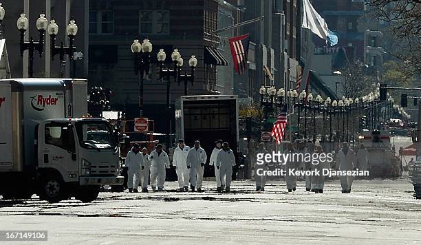 Law enforcement investigators walk the route of the Boston Marathon on Boylston Street looking for evidence after last Monday's bombings and two days...