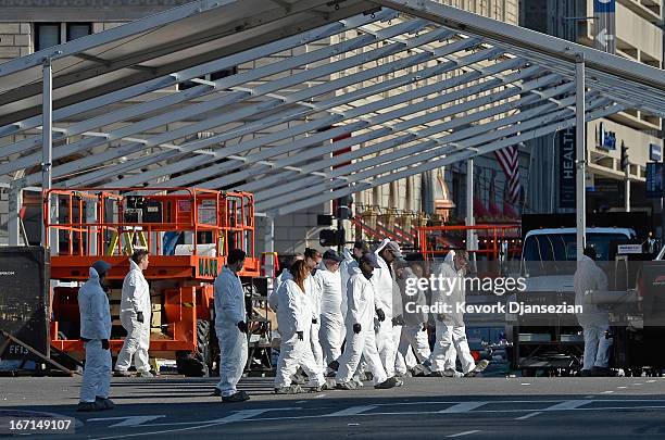 Law enforcement investigators work near the finsh line of the Boston Marathon on Boylston Street looking for evidence after last Monday's bombings...