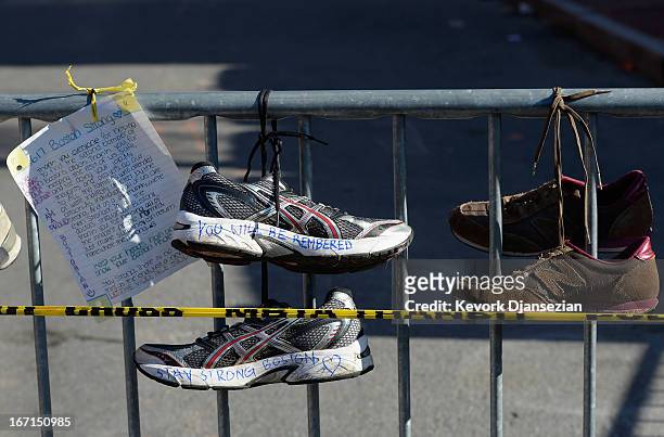Running shoes are placed at a makeshift memorial for victims near the finish line of the Boston Marathon bombings at the intersection of Newbury...