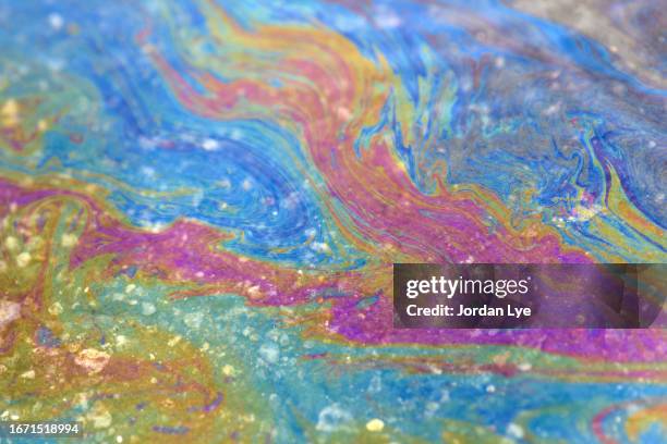 oil spill on the ground mixed with water - ölpest stock-fotos und bilder