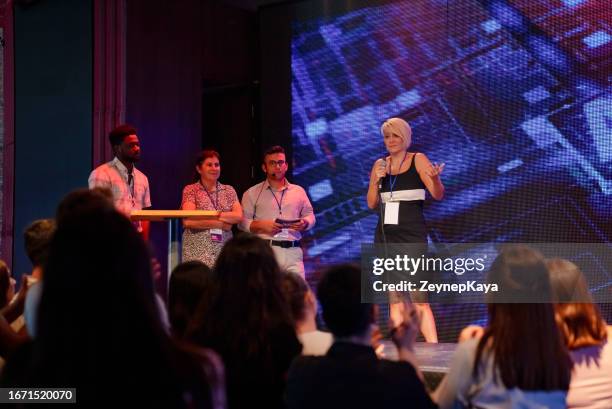 speeker talking and showing a presentation to audience on stage with microphone - awards dinners stock pictures, royalty-free photos & images