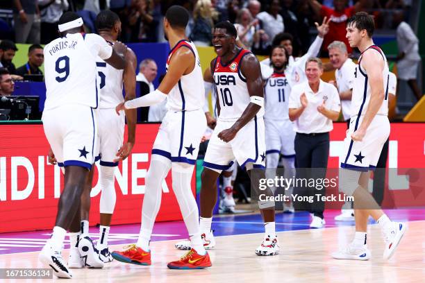 Anthony Edwards and Austin Reaves of the United States celebrates a three-pointer by Mikal Bridges to tie the game late in the fourth quarter during...