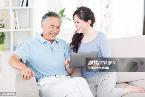 two senior asian people with digital tablet - minimalist living in japan stock pictures, royalty-free photos & images