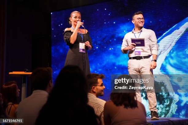 speeker talking and showing a presentation to audience on stage with microphone - 贊助者 個照片及圖片檔