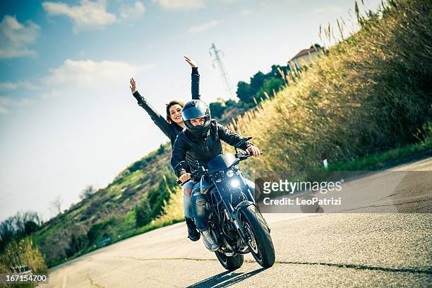 riding on a fast motorcycle with girlfriend - biker stockfoto's en -beelden