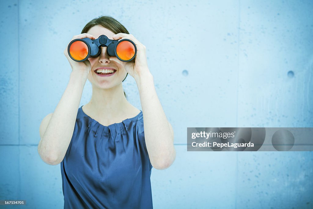 Businesswoman holding binoculars