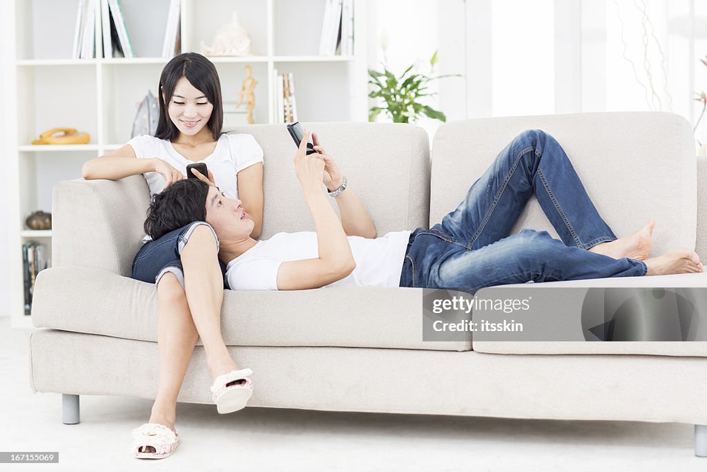 Young Asian couple using phones