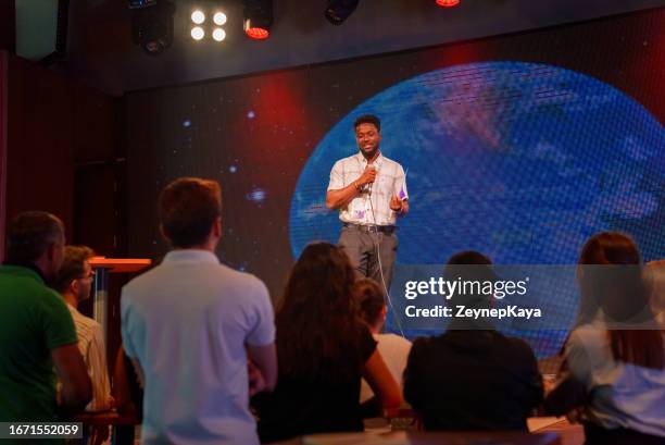 speeker talking and showing a presentation to audience on stage with microphone - business awards ceremony stock pictures, royalty-free photos & images