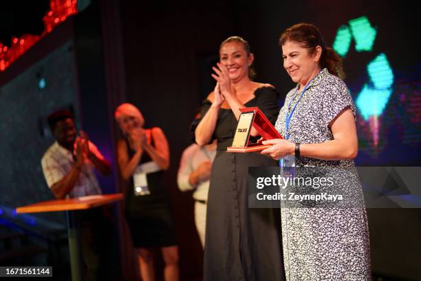 mulher adulta está recebendo um prêmio no palco por seu discurso - cerimónia de entrega de prémios - fotografias e filmes do acervo