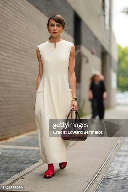 Mary Leest wears a white sleeveless dress, a burgundy leather bag, red socks and flat shoes, outside Tibi , during New York Fashion Week, on...