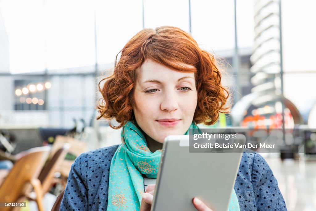 Woman looking at digital tablet in urban space