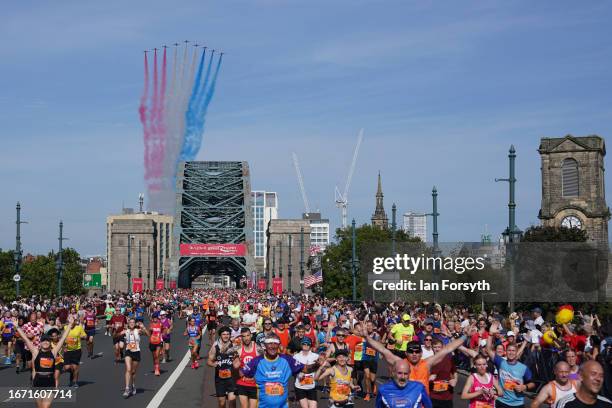 The Red Arrows Royal Air Force aerobatic display perform a flypast as runners cross the Tyne bridge during the AJ Bell Great North Run on September...