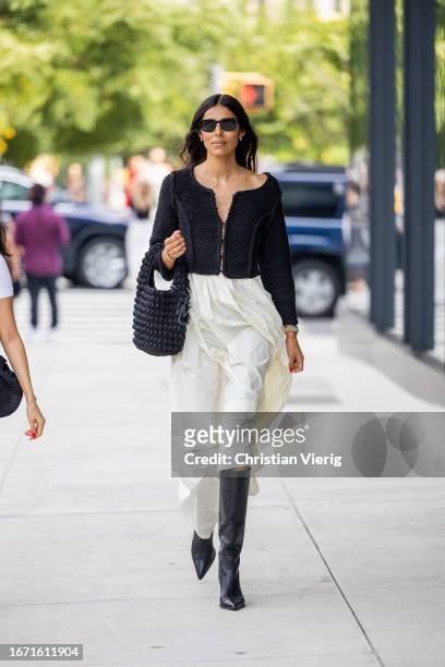 Babba Rivera wears white skirt, black bag, cropped jacket, boots outside Bevza on September 09, 2023 in New York City.