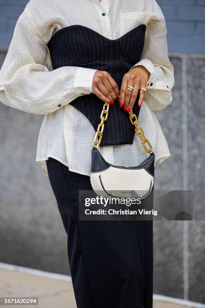 Guest wears black striped corset, white button shirt, skirt with slit outside Bevza on September 09, 2023 in New York City.