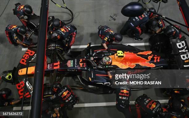 Mechanics work on the car of Red Bull Racing's Mexican driver Sergio Perez in the pit lane during the Singapore Formula One Grand Prix night race at...