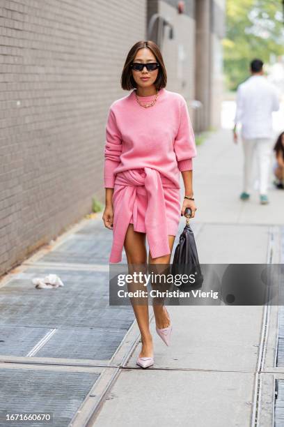 Aimee Song wears pink cashmere jumper, skirt outside Tibi on September 09, 2023 in New York City.