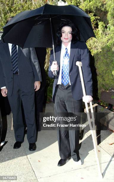 Singer Michael Jackson arrives at the Santa Maria Superior Court on crutches for an early morning court appearance on December 4, 2002 in Santa...