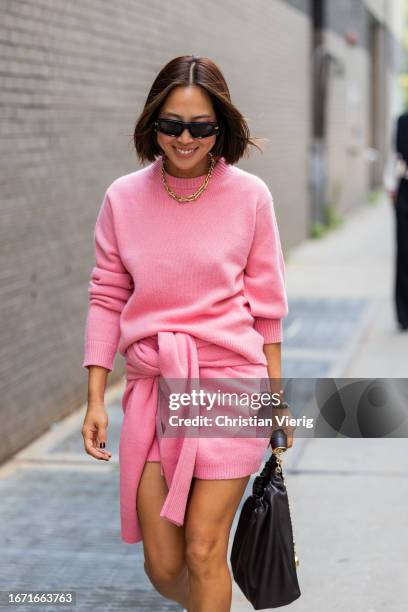 Aimee Song wears pink cashmere jumper, skirt outside Tibi on September 09, 2023 in New York City.