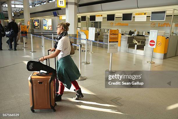 Young American woman who was planning to tarvel to Venezuela walks past a closed Lufthansa check-in counter at Tegel Airport during a nationwide...