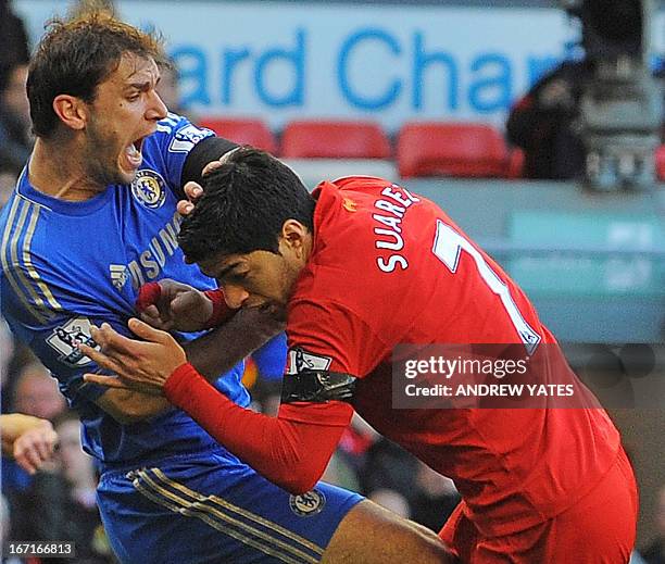 Liverpool's Uruguayan striker Luis Suarez clashes with Chelsea's Serbian defender Branislav Ivanovic after appearing to bite the Chelsea player...