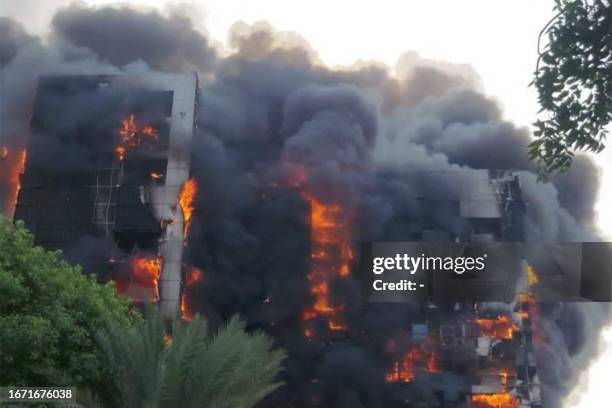 This picture taken on September 17, 2023 shows a raging fire at the Greater Nile Petroleum Oil Company Tower in Khartoum. Battles between the regular...