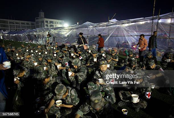 Soldiers have a meal at a makeshift shelter in BaoXing county, one of the hardest hit areas of the earthquake zone, on April 21, 2013 in China. A...