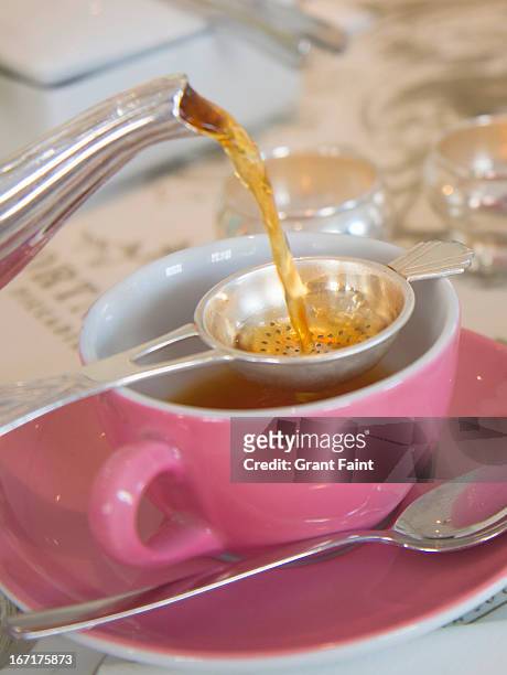 pouring english tea into cup - teesieb stock-fotos und bilder