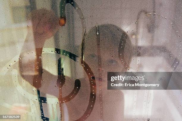 boy (6-7) drawing happy face on shower glass - condensation drawing stock pictures, royalty-free photos & images