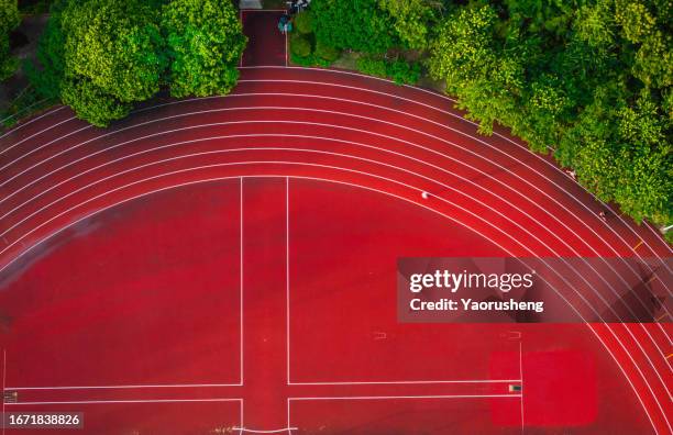 aerial view of runners running on red tartan track in the morning, like music note - track and field stadium stockfoto's en -beelden