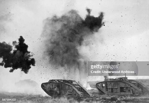 British tanks in action during WWI with German shells bursting around them, Europe, 1917.