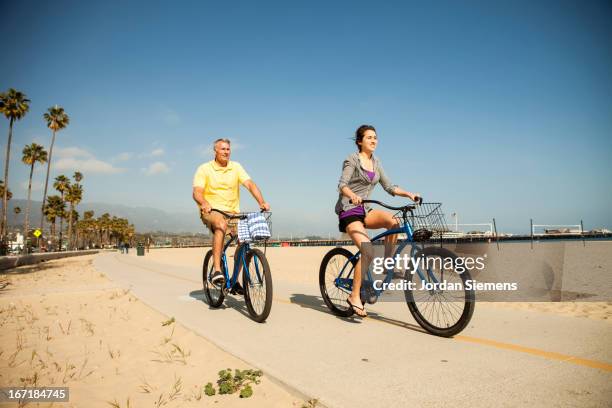 riding cruiser bikes. - boardwalk stock pictures, royalty-free photos & images