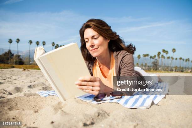 reading on vacation. - woman on beach reading stock pictures, royalty-free photos & images