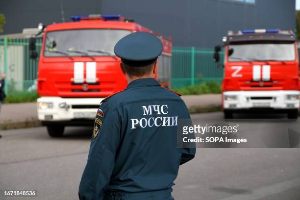 An employee of the Ministry of Emergency Situations of Russia examines fire trucks in Saint Petersburg, in the Primorsky Victory Park at...