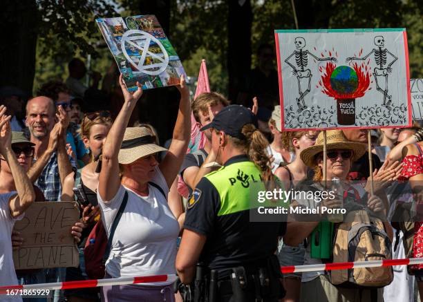 Climate activist stands opposite a police officer as the A12 motorway is blocked for the second day in a row in protest against the government’s...