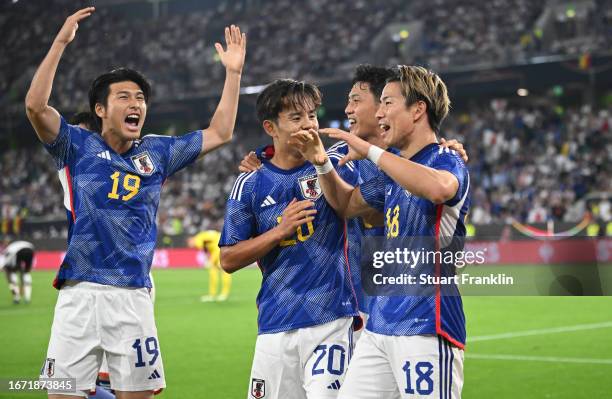 Takuma Asano of Japan celebrates with teammates after scoring the team's third goal during the international friendly match between Germany and Japan...