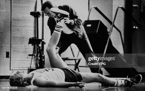 American basketball player Larry Bird, Celtics small forward, has leg worked on by Celtics American trainer Ray Melchiorre during a Boston Celtics...