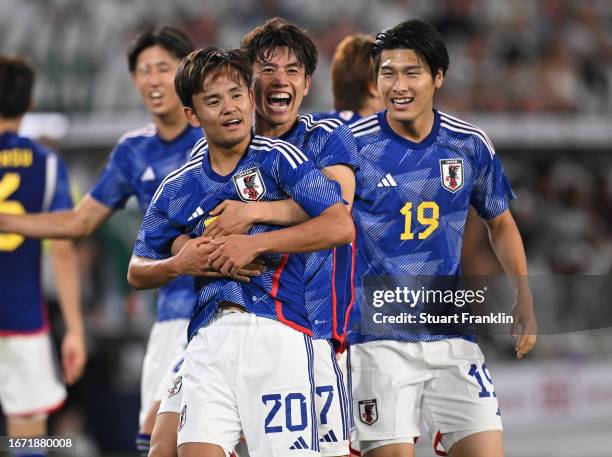 Takuma Asano of Japan celebrates with Kaoru Mitoma and Daiki Hashioka after scoring the team's third goal during the international friendly match...