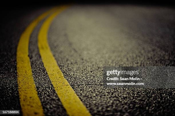 double yellow line on cracked asphalt - straßenmarkierung stock-fotos und bilder