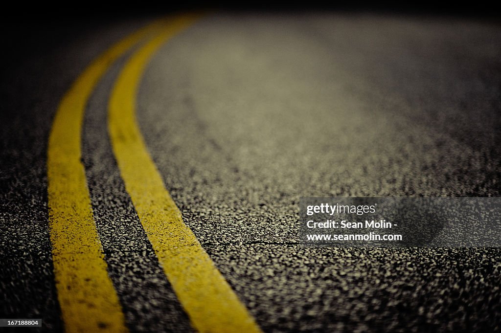 Double yellow line on cracked asphalt
