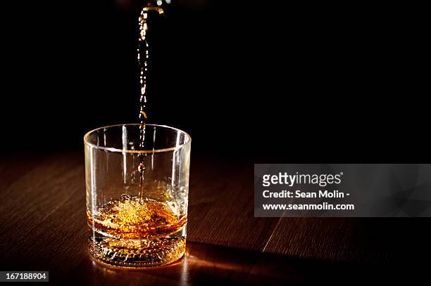 whiskey being poured into a glass - whiskey stock pictures, royalty-free photos & images