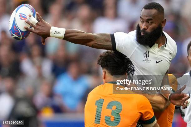 Fiji's left wing Semi Radradra passes the ball as he is tackled by Australia's outside centre Jordan Petaia the France 2023 Rugby World Cup Pool C...